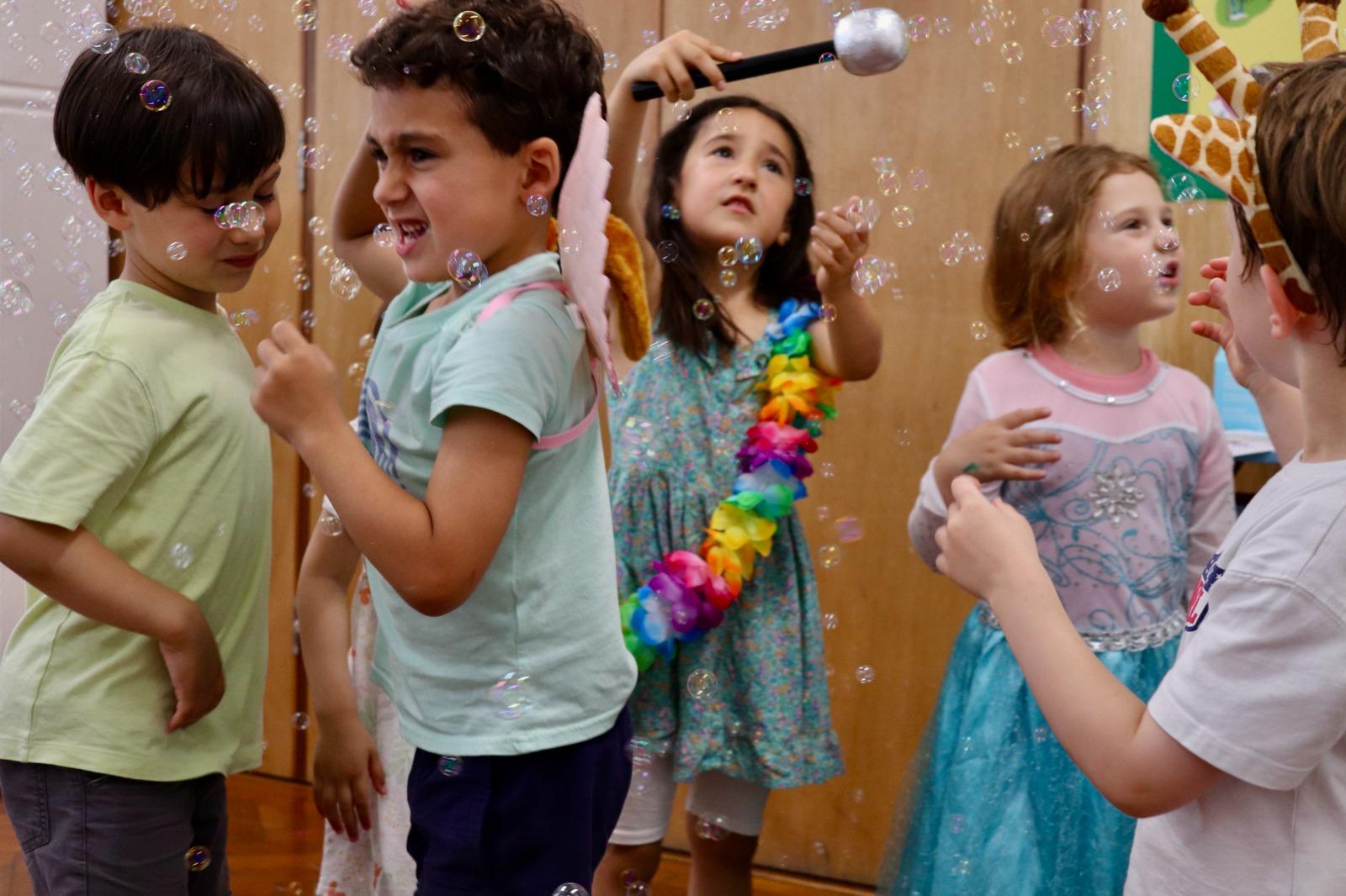 Younger children dancing through bubbles