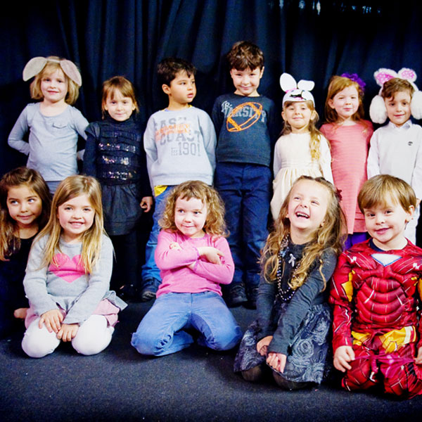 A class of children posing after a performance