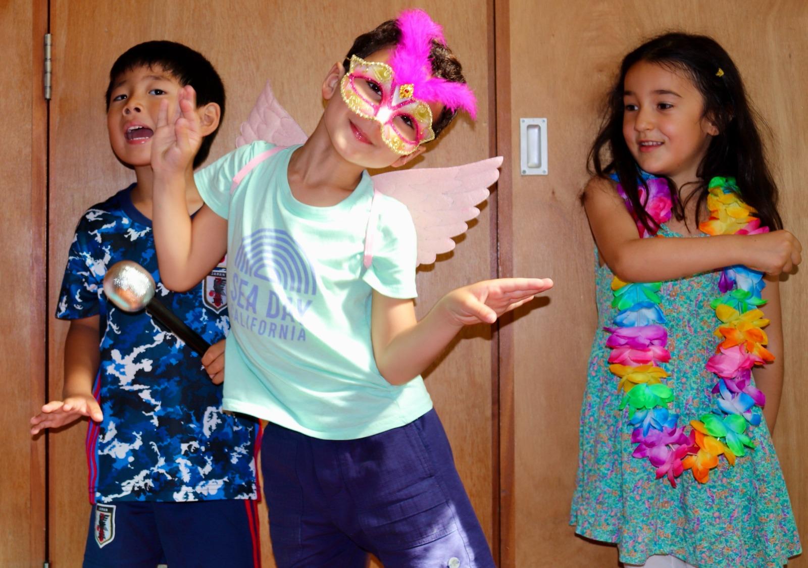 Three young performers singing with a toy microphone