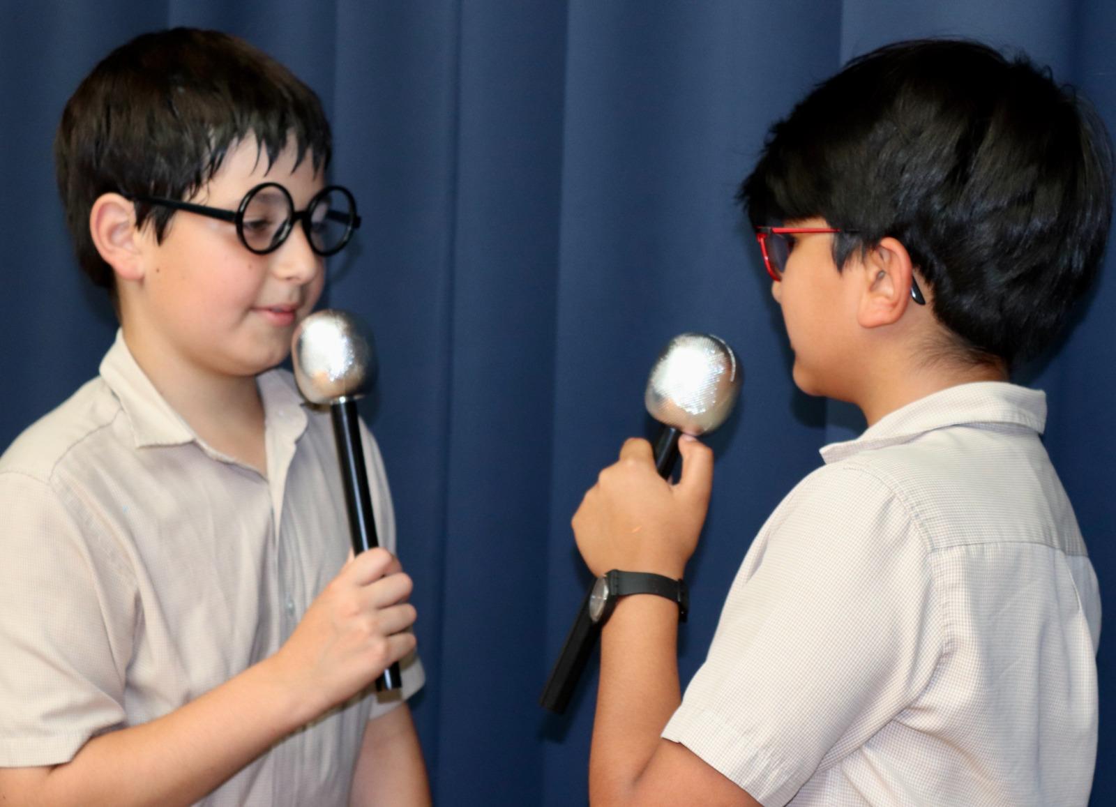 Two boys interviewing each other with toy microphones